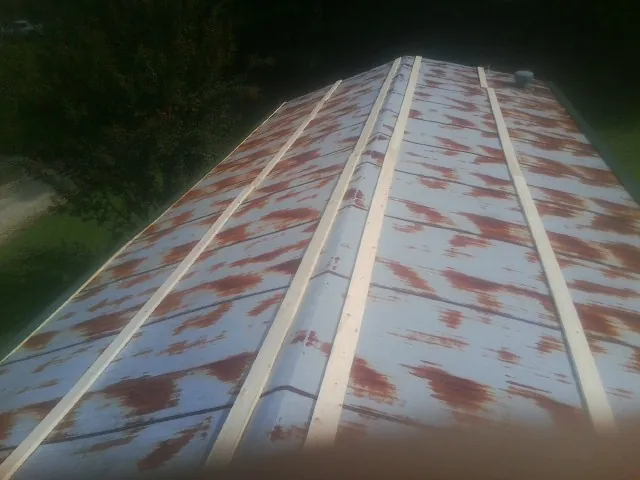 Rusted metal roof panels with new wood purlins before replacement — Storm Damage Roof Repair in Jericho by Roofing Brothers