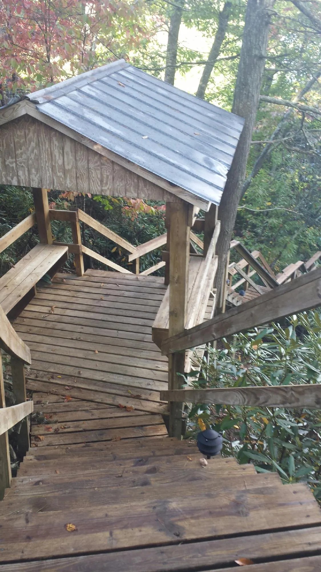 Metal roofed shelter over wooden steps on a wooded walkway — Skylight Repair & Installation work by our crew in Jericho
